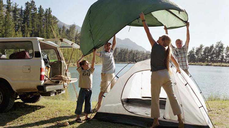 家庭 setting up a tent for camping.